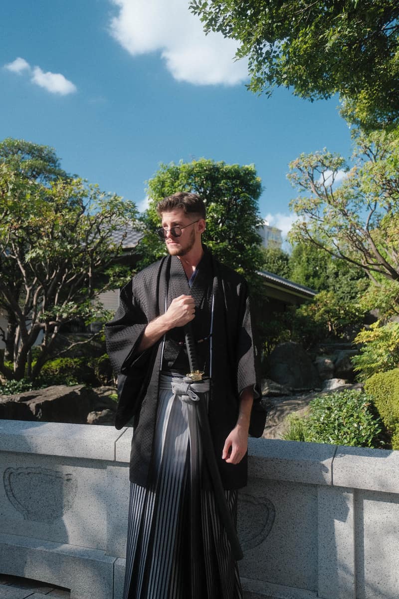 Men's kimono outfit with a black haori worn over striped hakama